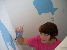 Laura decorates the walls of the bathroom
